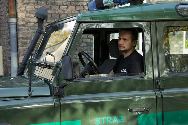 Bartłomiej Topa oraz radiowóz Land Rover Defender w serialu „Wataha”, foto: TVN Warner Bros. Discovery